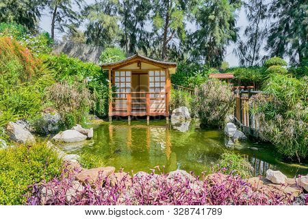 Japanese House In A Japanase Garden With Vegetation.