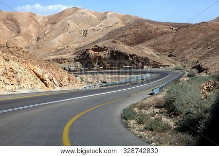 Curvy Sandy Road On A Highway That Runs Along The Dead Sea From One Side And Edom Mountains At Arava
