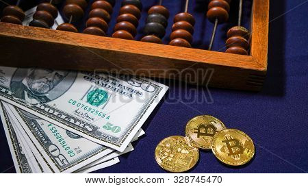 Bitcoins On The Background Of Dollars. Golden Bitcoins. Symbolic Coins Of Bitcoin On Banknotes . Exc