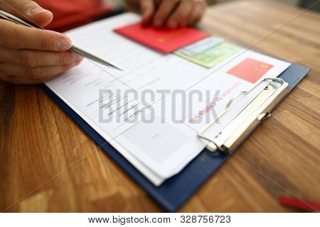 Male Hand Hold Silver Pen With Passport. Filling China Apllication Form Concept