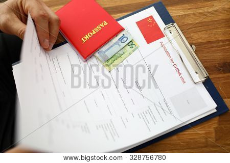 Male Hand Hold Silver Pen With Passport. Filling China Apllication Form Concept