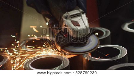 Hot Sparks Flying In The Air From A Circular Metal Grinder When Grinding Pipe Heads