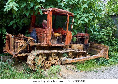 Old Rusty Soviet Tractor, Standing In The Grass