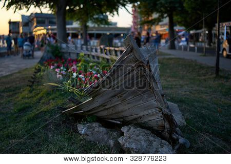 Old Wooden Boat As A Decoration (flowerbed With Flowers) On The Streets Of The Seaside Town. Pomorie
