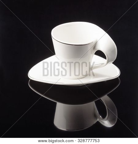 Porcelain Clay Cup For Coffee Or Tea With Sauser On The Black Mirror Background. Copy Space.