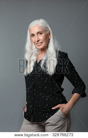 Portrait Of Beautiful Mature Woman On Grey Background