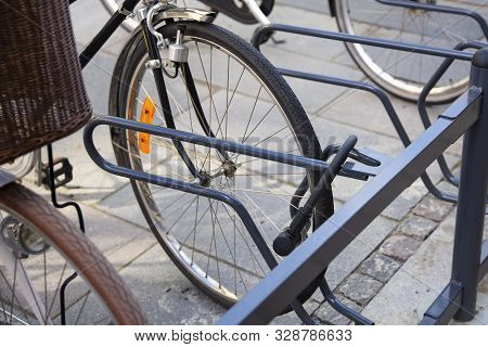 Bike Locked Securely Via U-lock In Bicycle Parking Area. Front Right Side View Of Front Wheel. Secur
