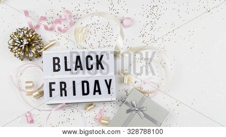 Black Friday Sale Text On White Lightbox, Golden Stars, Holiday Ribbon And Box Around On White Backg
