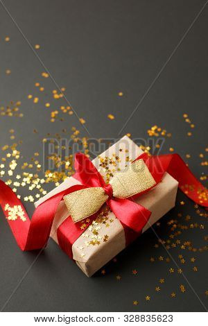 Gift Or Present Box And Gold Stars Confetti On Black Table Top View. Flat Lay Composition For Birthd