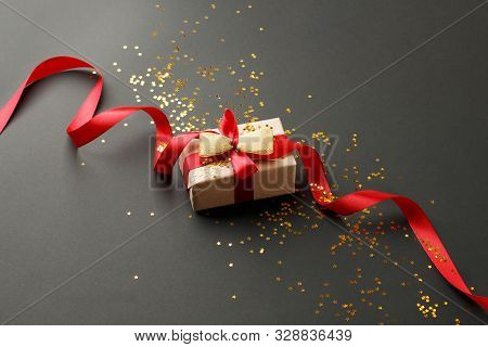 Gift Or Present Box And Gold Stars Confetti On Black Table Top View. Flat Lay Composition For Birthd