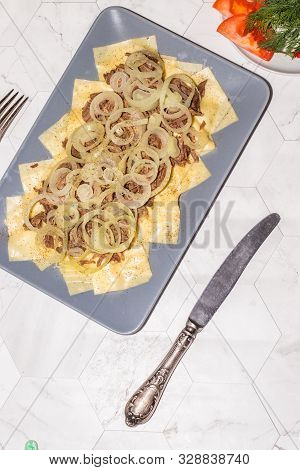 Beshbarmak Is A National Kazakh Dish - Square Pasta With Boiled Meat And Onions. On A Light Backgrou