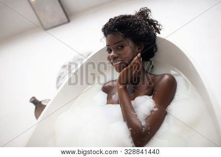 Curly Appealing Woman Having Good Mood While Chilling In Bath