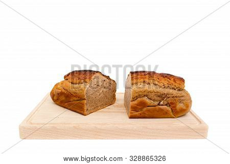 A Homemade Plumcake Standing On A Wooden Board With A White Background