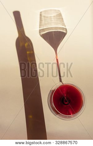 A Spectacular Long Shadow Falls From The Glass With Wine, Next To It Is The Shadow Of A Bottle Of Wi
