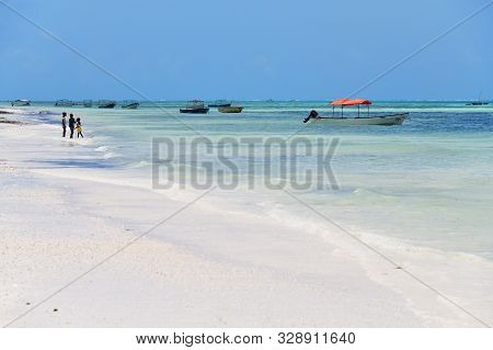 Pingwe, Zanzibar - October 6, 2019: Pingwe Beach, Fishing Boats And Local Children On The Shore. Tan