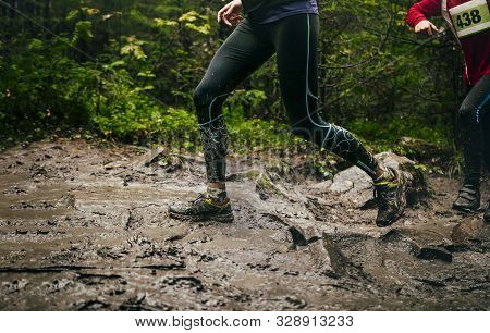 Dirty Feet Woman Runner Run Mountain Trail In Autumn Through Mud And Puddles