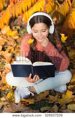 Activate Listening. Small Child In Headphones Practice Listening Comprehension. Little Girl Read Boo