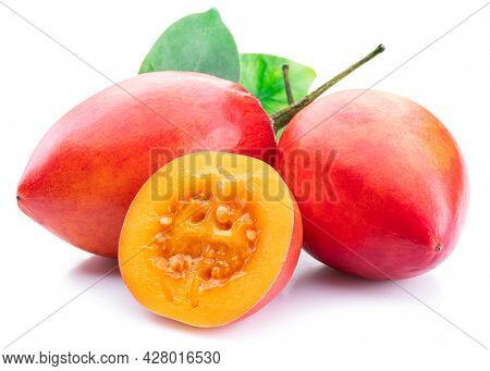 Ripe tamarillo fruits with slices and tamarillo leaves isolated on a white background.