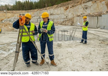 Two professional surveyors working by total station at construction site