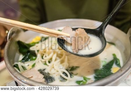woman eat a bowl of tonkotsu ramen in the restaurant