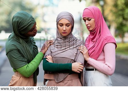 Three Muticultural Muslim Women Supporting Depressed Friend Outdoors