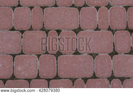Road Tiles Of Different Sizes. Top View. The Uneven Pink Color Of The Tile Makes It Look Like A Natu