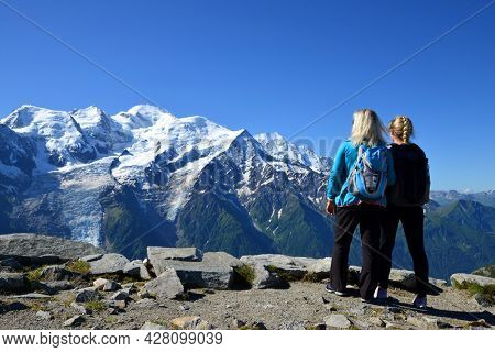 Hikers looking at the Mount Blanc from the summit of Le Brevent. French Alps, Chamonix, France.