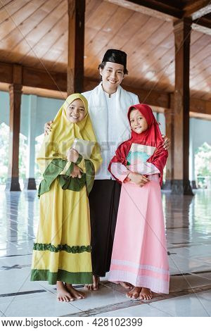 Portrait Of An Muslim Teacher And Muslim Children Holding The Al Quran Book