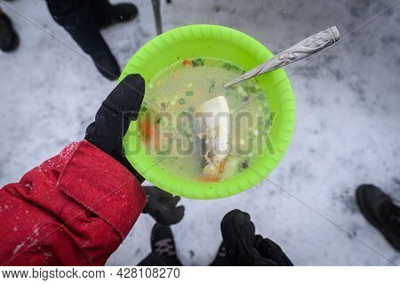 Tourist Holding A Hot Of Omul Fish Soup In Hand During Picnic In Lake Baikal, Russia. The Omul Fish 