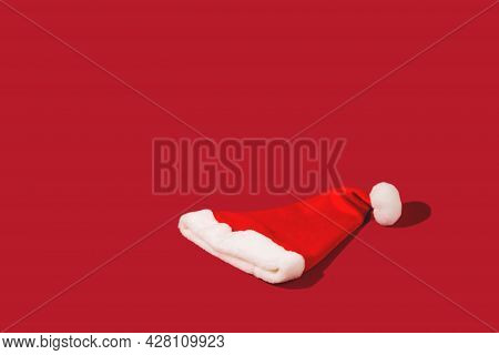 Red Santa Claus Hat On Monohomic Background. Minimalistic Christmas Composition. Creative Background