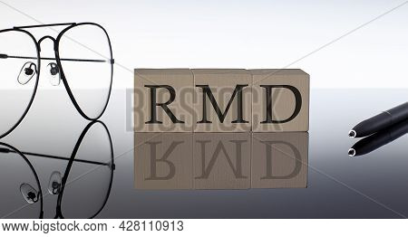 Close-up Of Rmd Wooden Blocks On Black Background With Glasses And Pen