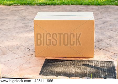 Parcel Box Delivered To A Front Door Of Residential Building. Online Shopping And Delivery. Post Shi