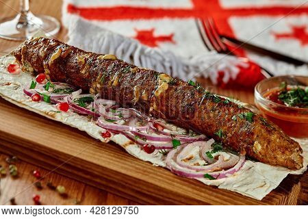 Beef And Cheese Kebab With Lavash, Onion, Pomegranate Seeds And Satsebeli In Georgian Restaurant