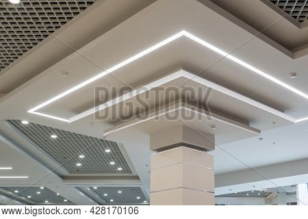 Suspended And Grid Ceiling With Halogen Spots Lamps And Drywall Construction In Empty Room In Store