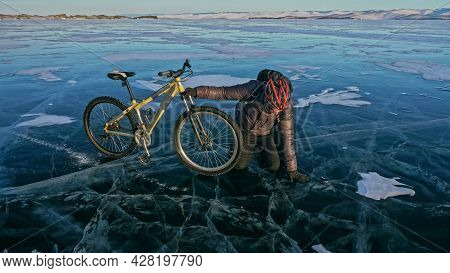 Man Is Riding Bicycle On The Ice. Ice Of Frozen Lake Baikal. Rid