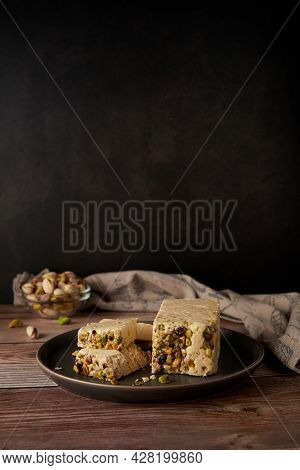 Organic Halva With Pistachios On A Wooden Surface. Traditional Middle Eastern Sweets. Jewish, turkis