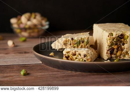 Organic Halva With Pistachios On A Wooden Surface. Traditional Middle Eastern Sweets. Jewish, turkis