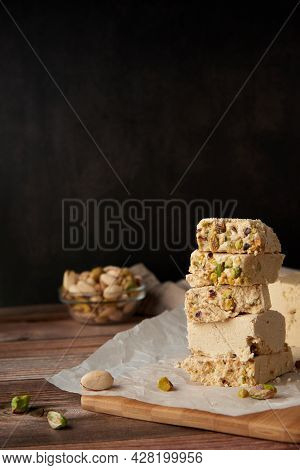 Organic Halva With Pistachios On A Wooden Surface. Traditional Middle Eastern Sweets. Jewish, turkis