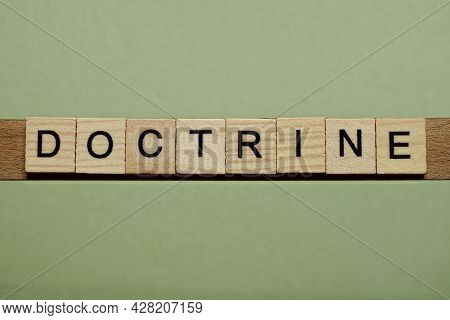 Gray Word Doctrine From Small Wooden Letters On A Green Table