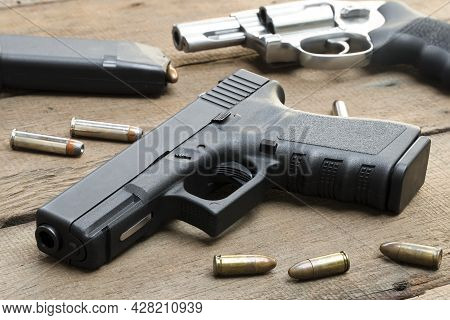 9mm Pistol, .357 Magnum Revolver, Bullets And ,magazines On Wooden Table
