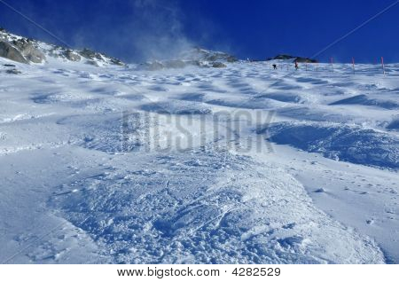 Skieurs traversant sur un champ de bosses sur un Glacier