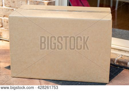 Parcel Box Delivered To A Front Door Of Residential Building. Online Shopping And Delivery. Post Shi