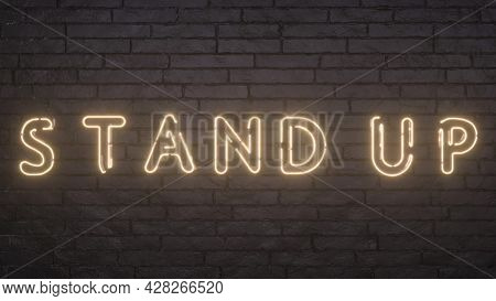 Glowing Stand Up Emblem On Black Brick Wall Background. 3d Rendering