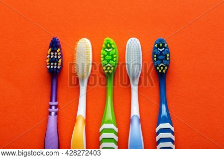 Toothbrushes On A Orange Background. Concept Toothbrush Selection. Oral Cavity Care. Dental Hygiene.