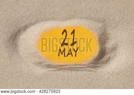 May 21. 21th Day Of The Month, Calendar Date. Hole In Sand. Yellow Background Is Visible Through Hol