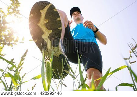 Closeup view of runner's shoes running throug the countryside