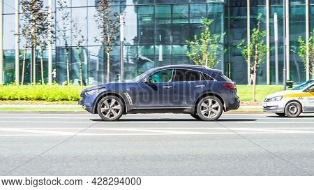 Moscow, Russia - July 2021: Dusty Infiniti Qx70 Is Accelerating On Highway On City Buildings Backgro