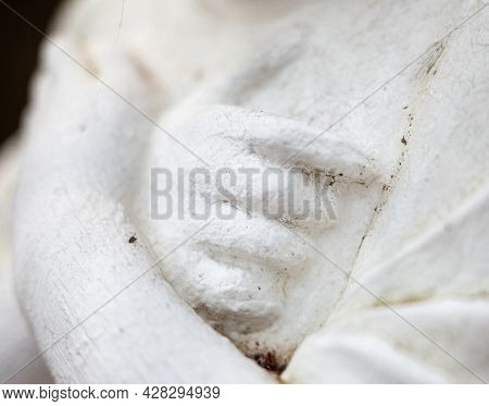 Hands On The Chest. Old Sculpture Of The Young Girl. Close-up.