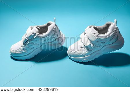 Two White Womens Soaring Running Shoes Simulate A Walk Isolated On A Blue Background