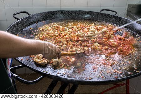 Start Of Preparation Of A Paella With A Base Or Sofrito Of Onion Tomato Chicken Meat In A Large Pael